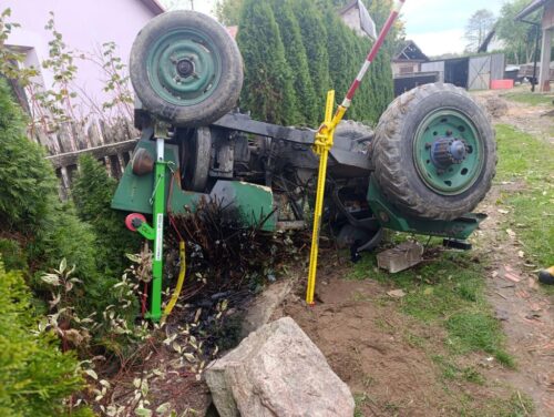 wypadek, wywrócony ciągnik, ranny mężczyzna, przygniecenie