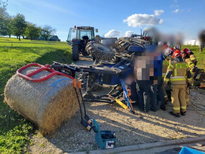 wypadek, wywrócony ciągnik, ranny traktorzysta, bela słomy